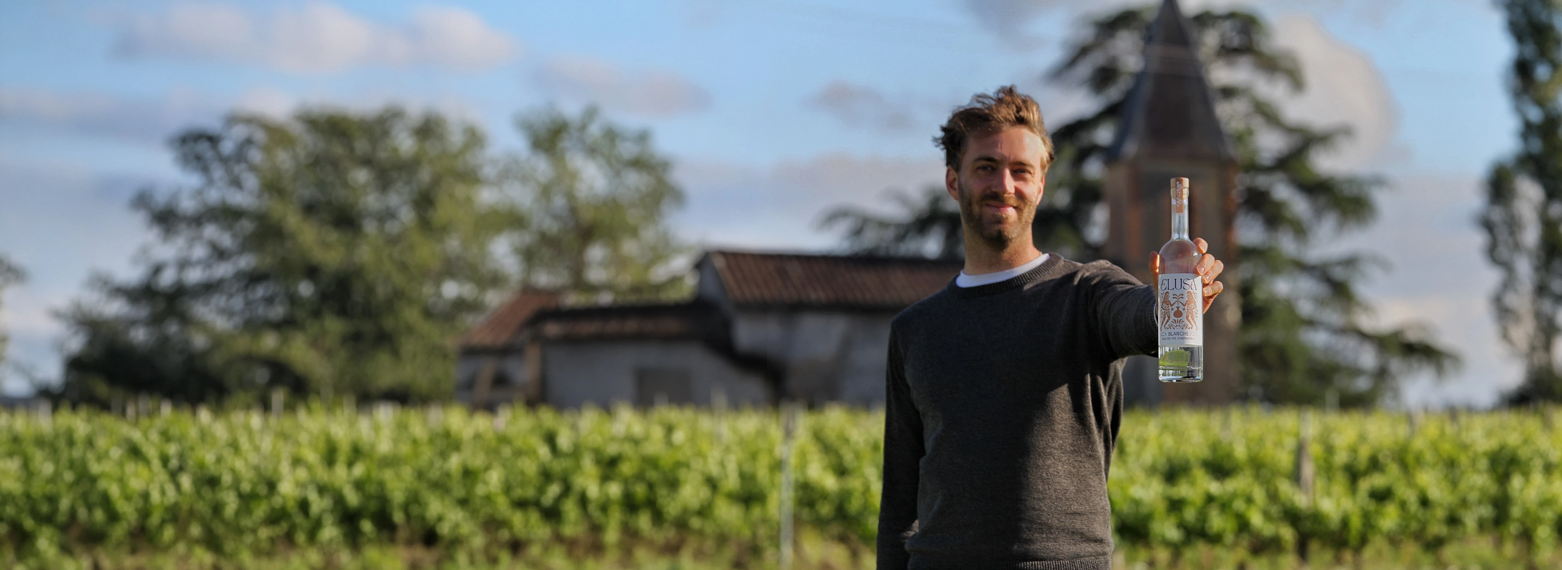 Founder Will Perkins holding Elusa Blanche Armagnac in the Gascony vineyard